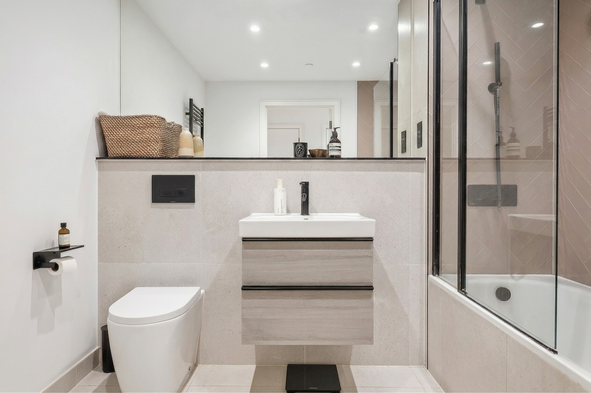 Bathroom in stone tones with shower over bath