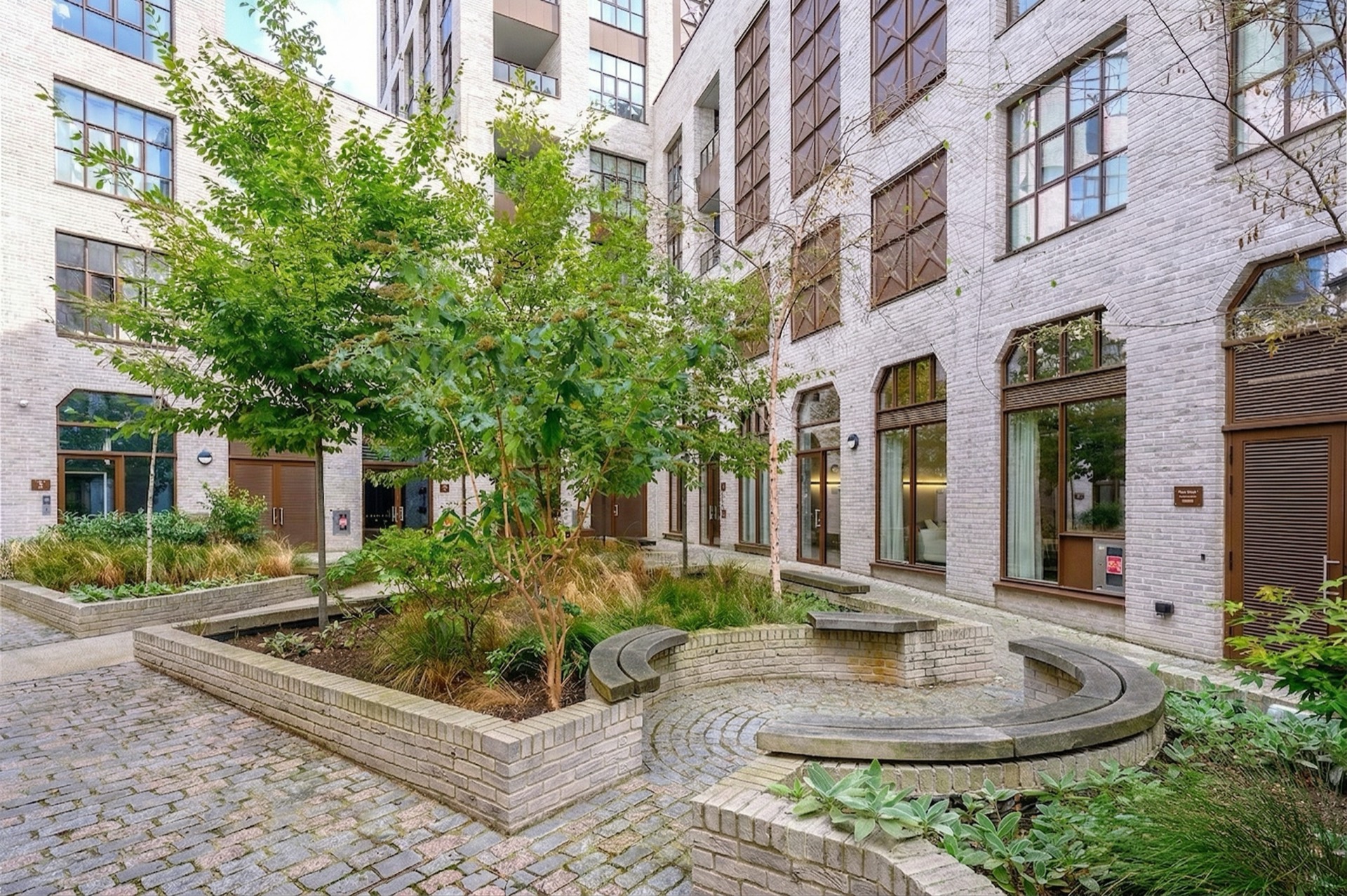 The landscaped courtyard at Empress Works: brick planters and young trees